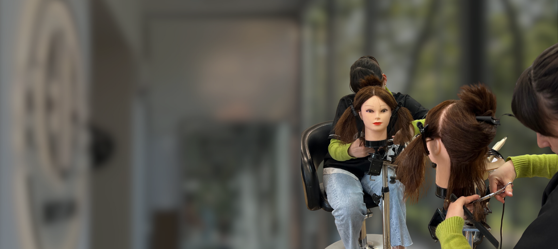 Academy students practising haircutting techniques on mannequin heads at Ela Beauty Salon