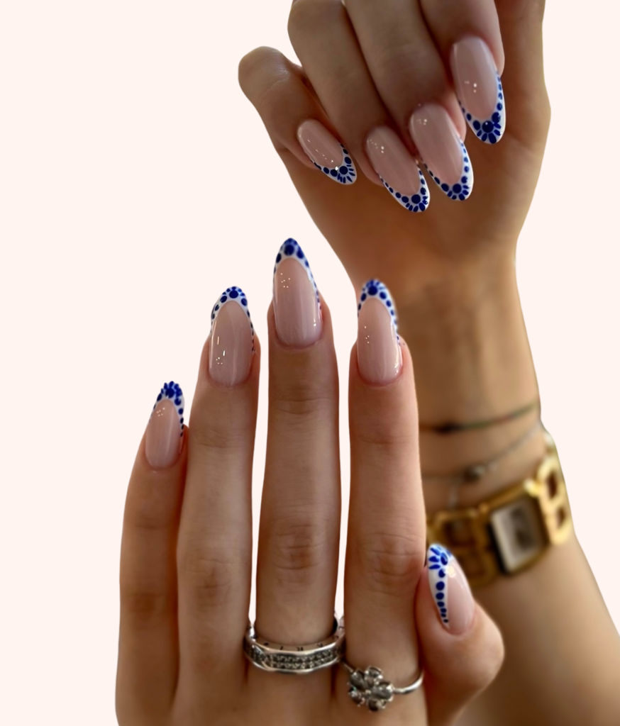 Almond nails with nude polish and blue-and-white floral French tips